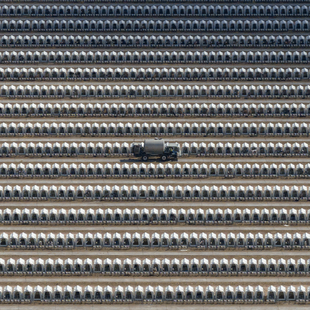 A milk dispenser truck drives between some of the thousands of calf hutches in a massive dairy farm’s yard. Turkey Creek Dairy, Pearce, Arizona, USA, 2023.  Ram Daya / We Animals